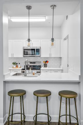 Sandy Springs apartment for rent - a kitchen with white cabinets and a counter with three stools