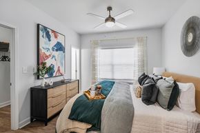 Sandy Springs apartment for rent - a bedroom with a large bed and a ceiling fan