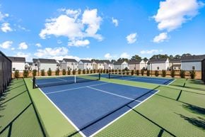 Myrtle Beach apartment for rent - A tennis court surrounded by houses and trees.