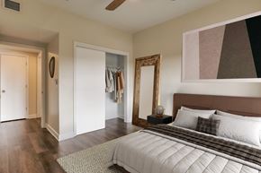 Pensacola apartment for rent - A bedroom with a large bed and a mirror on the wall.