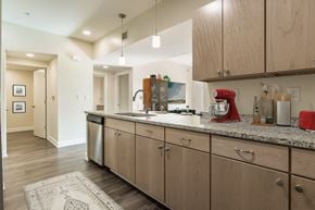 Pensacola apartment for rent - A kitchen with wooden cabinets and a red mixer.