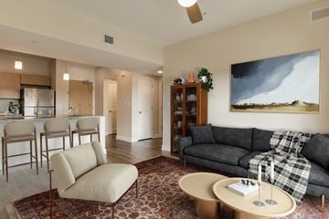 Pensacola apartment for rent - A living room with a grey couch and a painting on the wall.