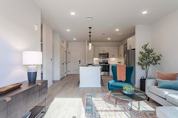 Spring Hill apartment for rent - A modern living room with a blue chair and a glass table.