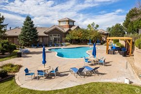 Aurora apartment for rent - South Aurora, CO, Apartments for Rent - Sonoma Resort at Saddle Rock - Pool with Lounge Seats, Umbrellas, Tables, Chairs, Pergola, and Surrounding Trees.