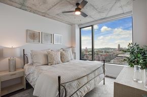 Nashville apartment for rent - A bedroom with a large bed and a view of the city.