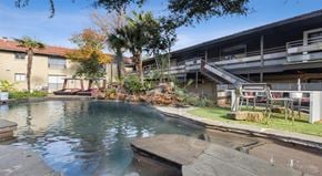 Dallas apartment for rent - a swimming pool with a building in the background