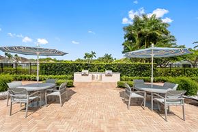 Boca Raton apartment for rent - A patio with a table and chairs under umbrellas.