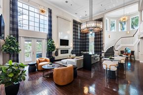 Boca Raton apartment for rent - A large, well-lit living room with a staircase and a dining table.
