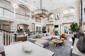Boca Raton apartment for rent - A spacious living room with a white sofa set and a chandelier hanging from the ceiling.