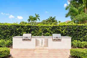 Boca Raton apartment for rent - A white outdoor kitchen with a grill and sink.