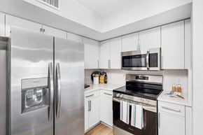 Boca Raton apartment for rent - A modern kitchen with a stainless steel refrigerator and white cabinets.