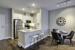 Chelmsford apartment for rent - A modern kitchen with a bar area and a dining table set for four.