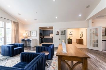 Raleigh apartment for rent - A living room with blue chairs and a wooden table.