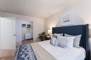 Raleigh apartment for rent - A bedroom with a large bed and a painting on the wall.
