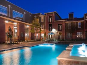 Dallas apartment for rent - A swimming pool in front of a building at night.