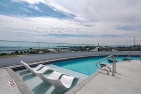 Milwaukee apartment for rent - a swimming pool on the roof of a building with two chairs