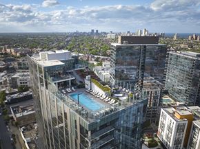 Chicago apartment for rent - a tall skyscraper with a pool on top of it overlooking a city