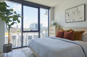Chicago apartment for rent - a bedroom with a bed and a view of the city