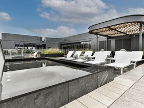 Washington apartment for rent - a pool with white lounge chairs in front of a building
