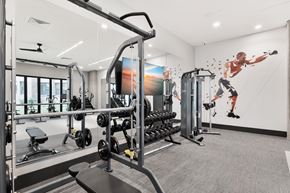 Atlanta apartment for rent - A gym with a variety of equipment including a treadmill, weights, and a bench.