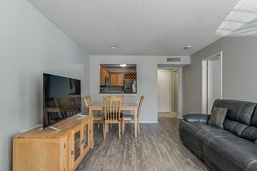 Nashville apartment for rent - A living room with a black leather couch and a wooden entertainment center.