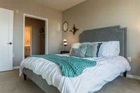 St Paul apartment for rent - a bedroom with a large bed and a door to a bathroom at the Vintage on Selby in St. Paul, MN