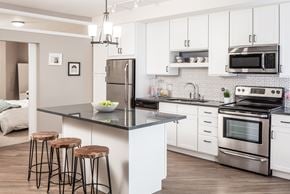 St Paul apartment for rent - a kitchen with stainless steel appliances and a counter with three stool at the Vintage on Selby in St. Paul, MNs