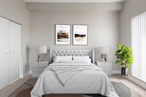 Haverhill apartment for rent - A bedroom with a large bed, two lamps, and two framed pictures on the wall.