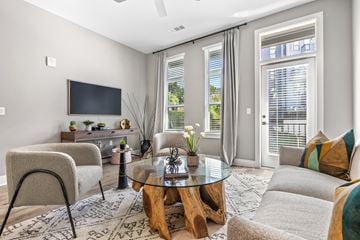 Asheville apartment for rent - A modern living room with a glass coffee table and a flat screen TV.
