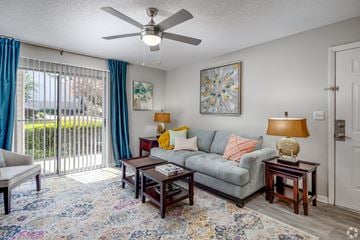 Columbia apartment for rent - A living room with a grey couch, a rug, a table with a lamp and a painting on the wall.