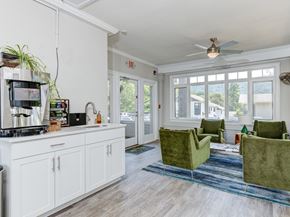 Asheville apartment for rent - A kitchen with white cabinets and a green chair.