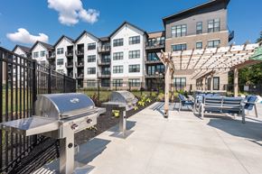 Carmel apartment for rent - One-Bedroom Apartments in North Indianapolis, IN - North End Apartments - Outdoor Grilling Station With Stainless Barbecue Grills, Pergola Seating, and Apartment Buildings In View.