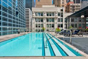 Chicago apartment for rent - A swimming pool with a blue tinted water in the middle of a city.