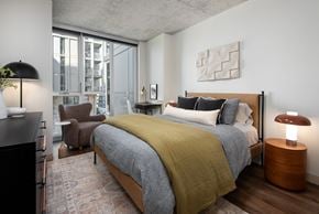 Chicago apartment for rent - A bedroom with a large bed and a chair.