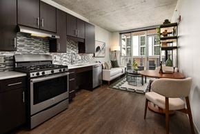 Chicago apartment for rent - A modern kitchen with dark wood cabinets and a stainless steel stove.