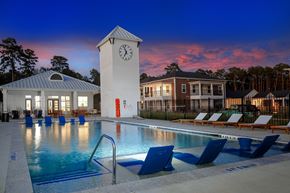 Conroe apartment for rent - a swimming pool with a clock tower at night