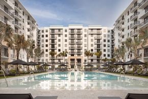 Miami apartment for rent - A large swimming pool in front of apartment buildings.