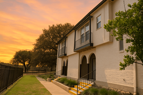 San Antonio apartment for rent - A white building with a balcony and a yellow staircase leading to the balcony.