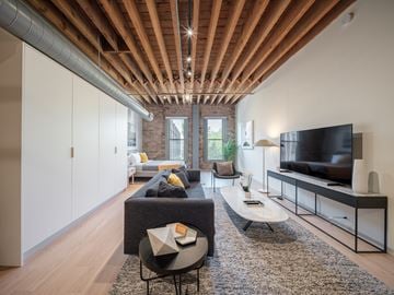 Chicago apartment for rent - A living room with a grey couch and a black television.