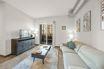 Tampa apartment for rent - A living room with a white couch and a wooden cabinet.