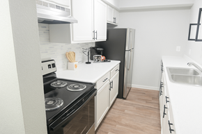 Longview apartment for rent - A kitchen with black appliances and white cabinets.