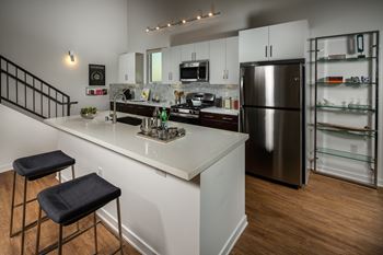 Exceptional modern kitchens with quartz countertop featuring contemporary tile backsplash, custom cabinets and moen water fixtures