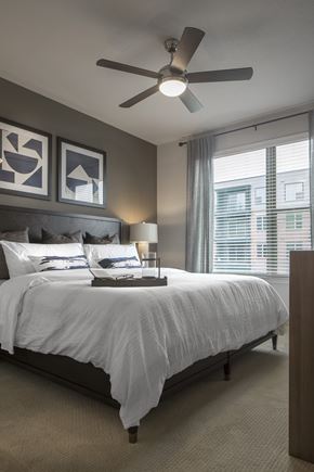 Houston apartment for rent - A bedroom with a large bed and a ceiling fan.
