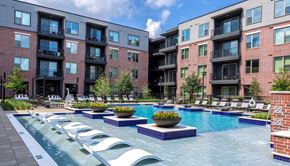 Houston apartment for rent - A pool with a white bench and a black planter.