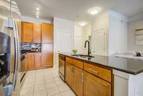 Camp Springs apartment for rent - Apartments Near National Harbor - Tribeca at Camp Springs - A kitchen with wooden cabinets and a black countertop