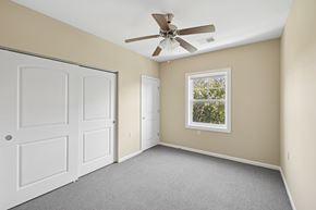 Independence apartment for rent - A room with a ceiling fan and a window showing trees outside.