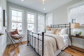 Nashville townhouse for rent - A bedroom with a large bed and a chair by the window.