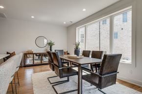 Nashville townhouse for rent - A dining room with a round mirror and a table with chairs.