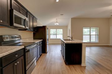 Foley apartment for rent - A kitchen with black cabinets and a marble countertop.