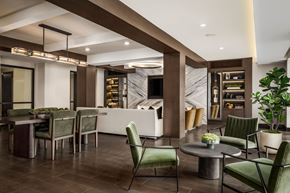 Dallas apartment for rent - A modern dining room with a long table and green chairs.